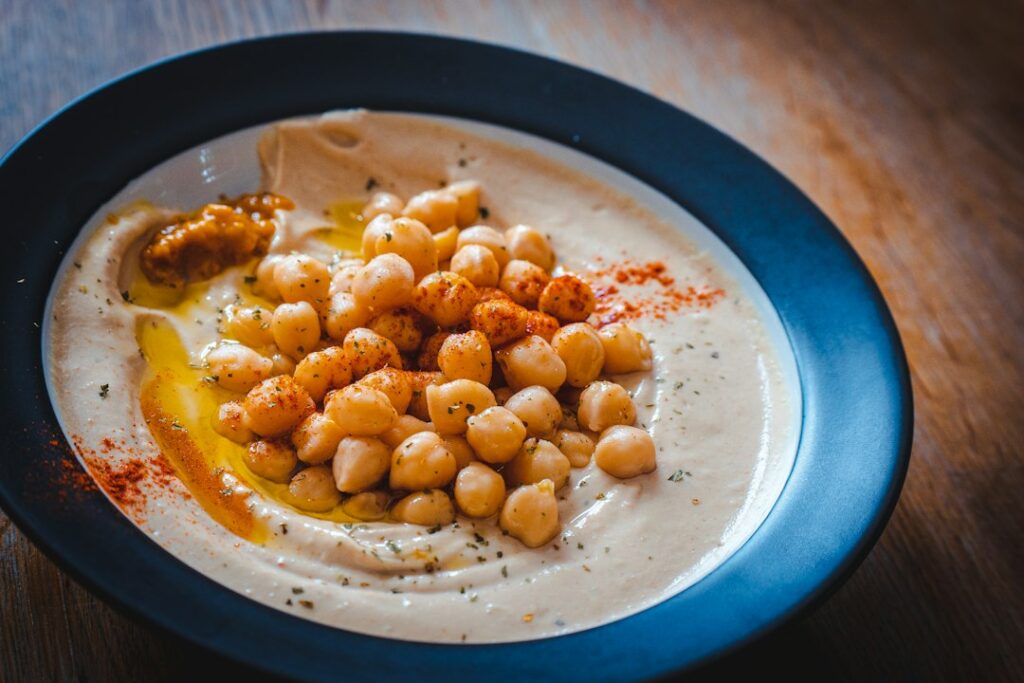 Bowl of hummus topped with chickpeas and olive oil, to answer is hummus low FODMAP