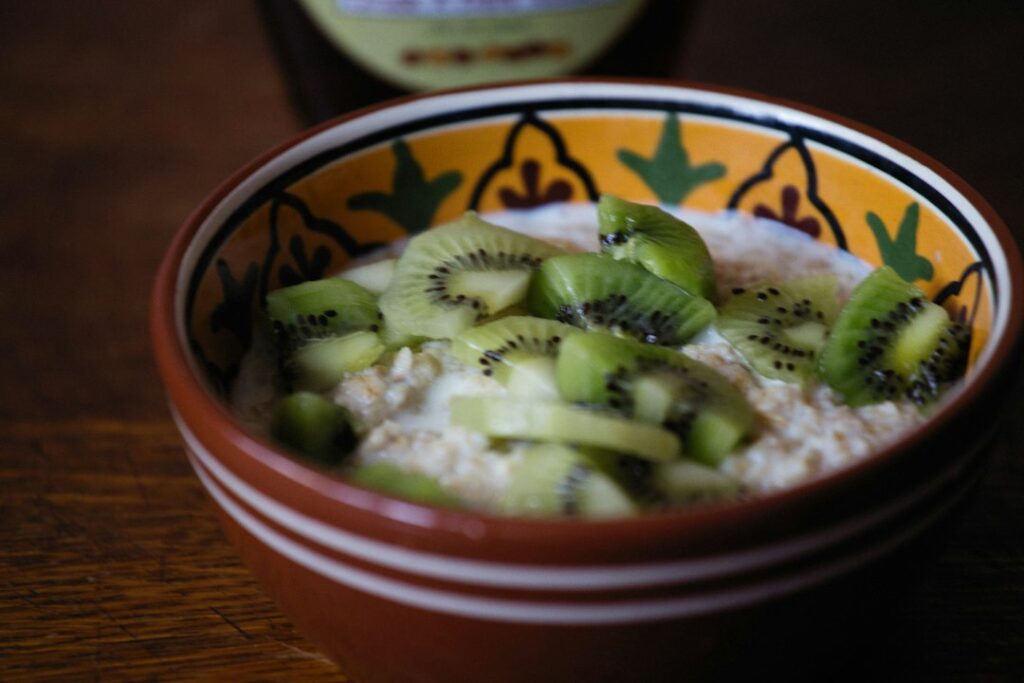 Bowl of oats topped with kiwi slices, a gentle fibre breakfast for an article on psyllium for IBS